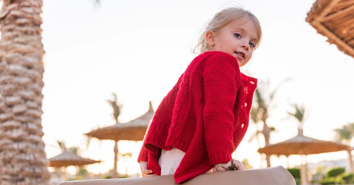 A little girl standing in front of a window