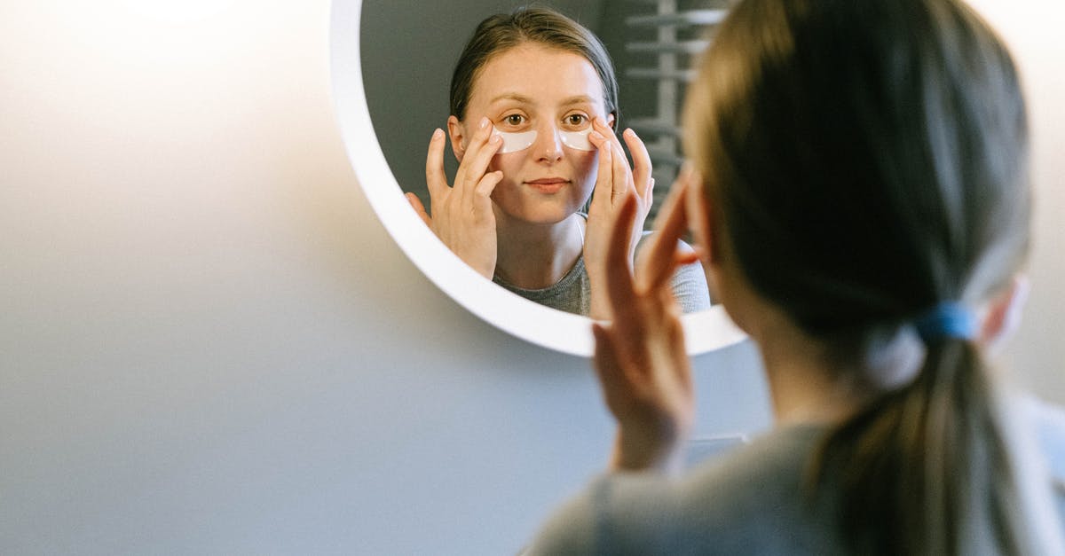 A woman standing in front of a mirror posing for the camera