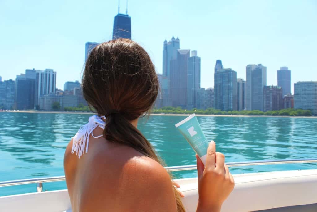 A woman sitting next to a body of water