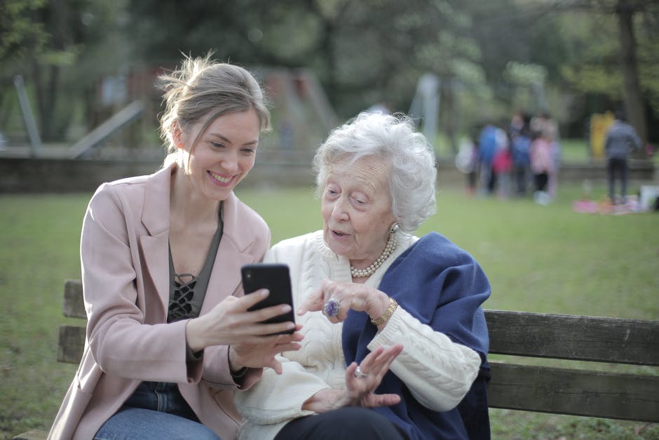 A woman sitting on a park bench looking at her cell phone