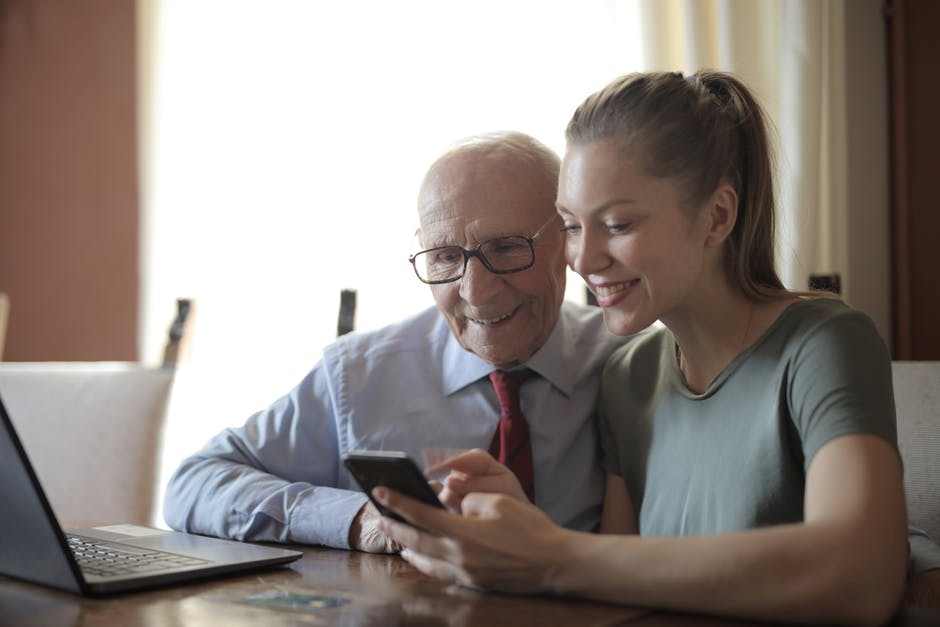 A man and a woman sitting at a table using a laptop