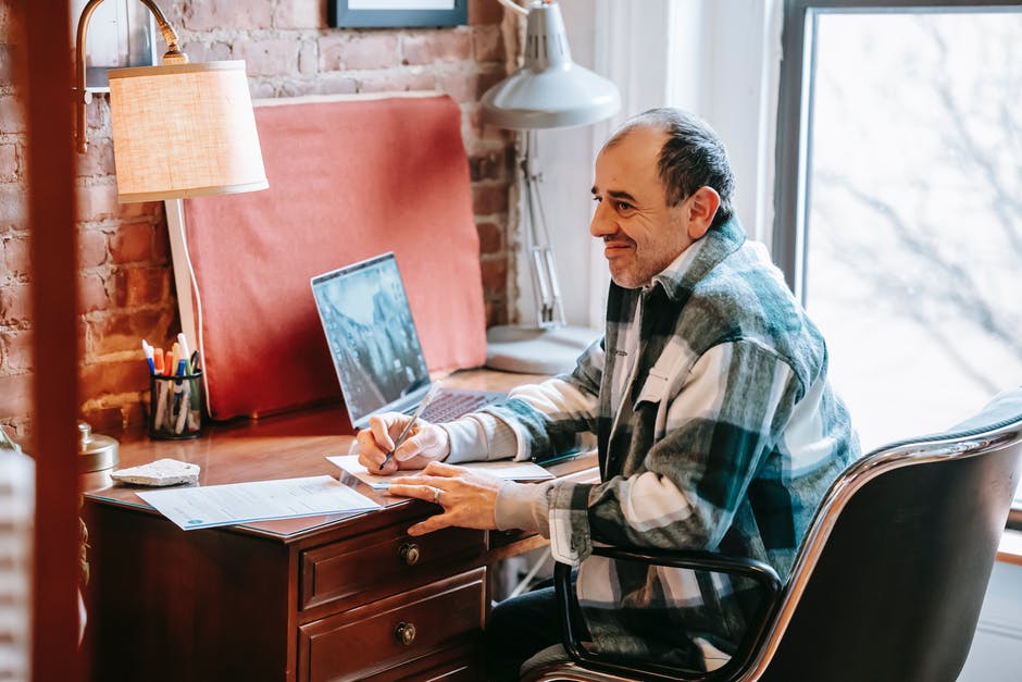 A man sitting at a desk in front of a window